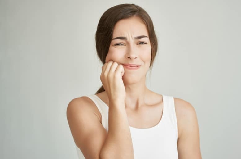 Woman experiencing severe tooth pain seeking emergency dental care in South Austin, TX.