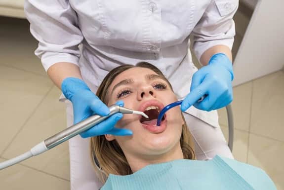 Dentist performing root canal procedure on patient using dental tools in South Austin clinic